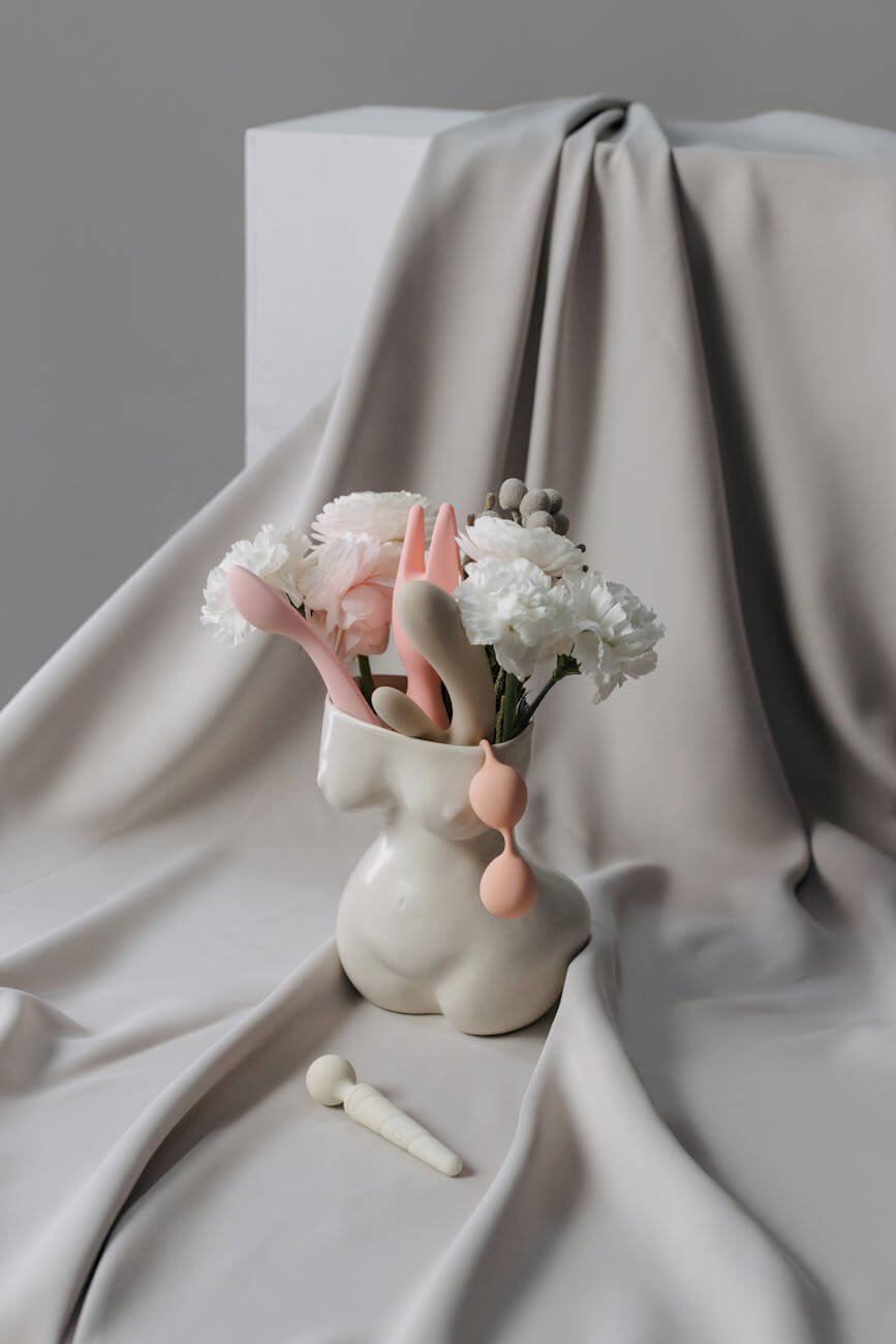 gray vase with white flowers and pastel colored objects